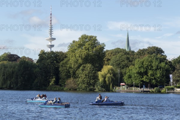 Leisure activities in summer, pedal boats against a blue sky on the Alster, with the Telemichel