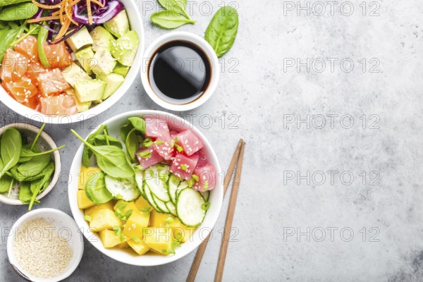 Two assorted poke bowls with raw fish and vegetables, space for text. Top view, close up. Hawaiian