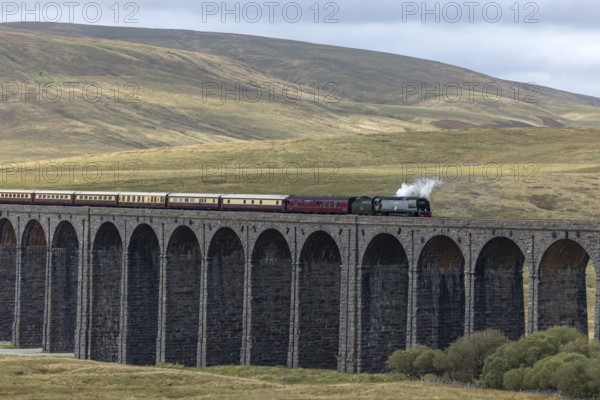 Steam train crossing Ribblehead Viaduct, railway bridge over the valley of the River Ribble at the