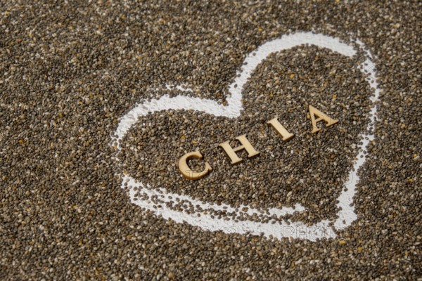 Heart made of chia seeds with word CHIA inside background. Healthy superfood rich in Omega 3 fatty