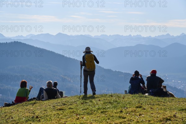 Hikers rest on the summit of Sonntratn, also known as Schürfenkopf, and look into the Karwendel,