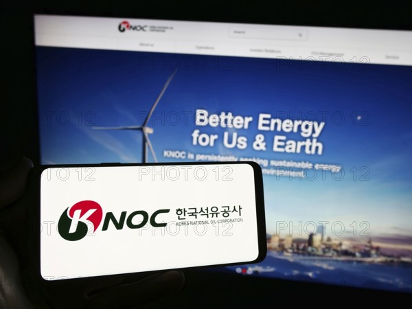 Stuttgart, Germany, 11-16-2023: Person holding smartphone with logo of petroleum company Korea