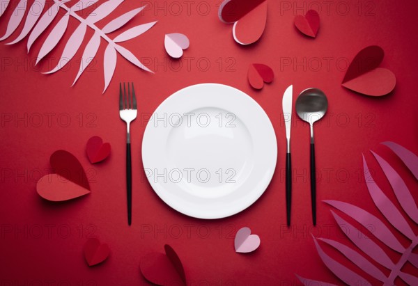 Romantic dinner at restaurant on Valentines day, paper art. White empty plate, spoon, fork, knife