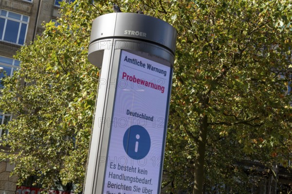 Symbolic image disaster control, advertising pillar with the display Official warning, test