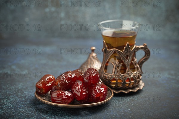 Breaking fasting with dried dates during Ramadan Kareem, Iftar meal with dates and Arab tea in