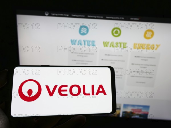 Stuttgart, Germany, 01-15-2023: Person holding cellphone with logo of French company Veolia