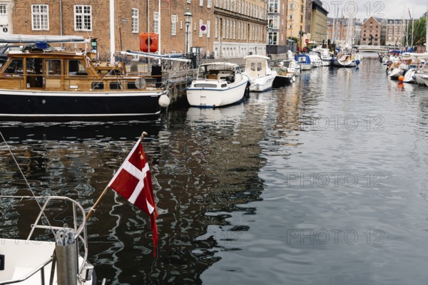 Copenhagen, Denmark, August 12, 2016: Port of Copenhagen with boats and ships moored. Danish flag