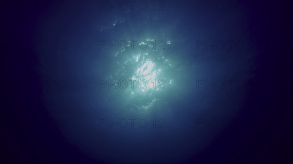 View of sun light from blue abyss, slow motion. Light filters down through blue water. Underwater