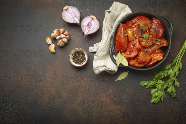 Cooking hearty meat stew. Raw uncooked chopped pieces of meat marinated with seasonings and parsley