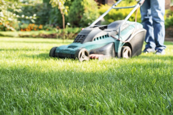 Man pushing lawn mower. Lawn care background, place for text