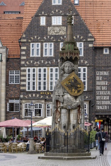 Stone statue with armour and coat of arms Bremen Roland on the market square in the old town of