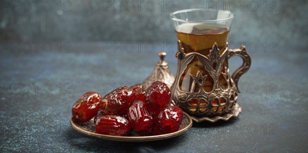 Breaking fasting with dried dates during Ramadan Kareem, Iftar meal with dates and Arab tea in