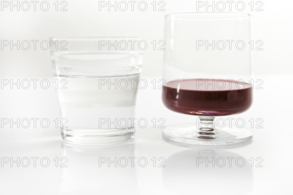 Glass of water and wine, two glasses together over white