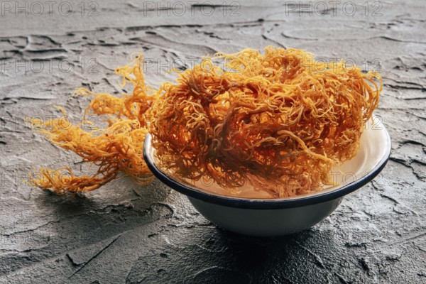 Irish sea moss, Chondrus Crispus, healthy organic raw seaweed, dried, in a bowl on a black slate