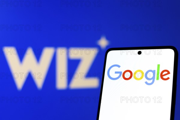 In this photo illustration, the Google logo is displayed on a smartphone screen, in the background