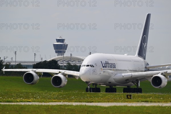 Lufthansa Airbus A380-800 with control tower taxiing from Terminal 2 to Runway North, Munich