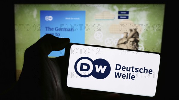 Stuttgart, Germany, 04-10-2024: Person holding mobile phone with logo of German state-owned