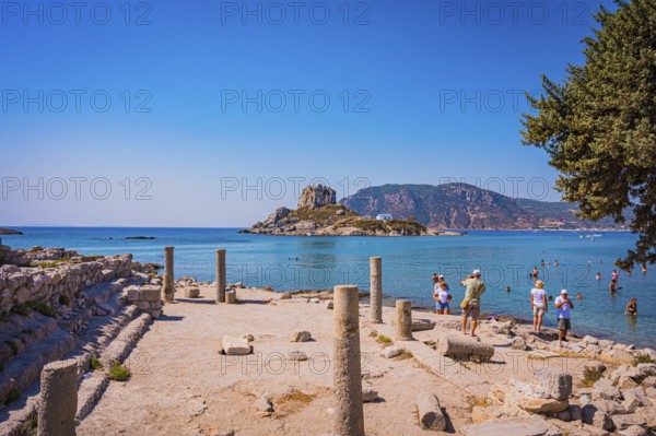 Ancient ruins on the shore with a view of the sea and a rocky island in the background, Agios