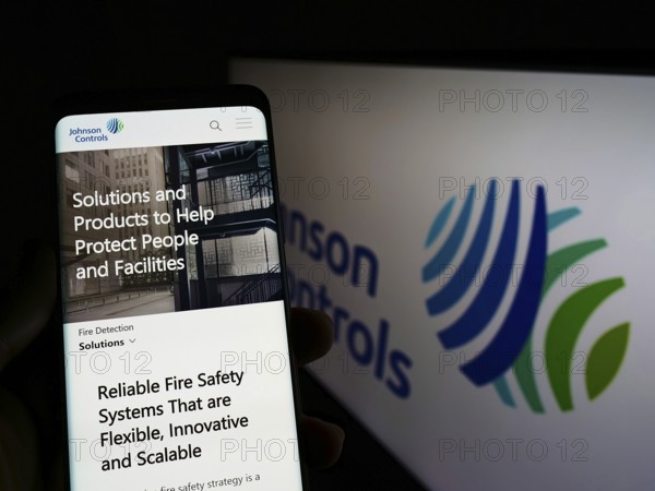 Stuttgart, Germany, 03-12-2022: Person holding cellphone with webpage of company Johnson Controls