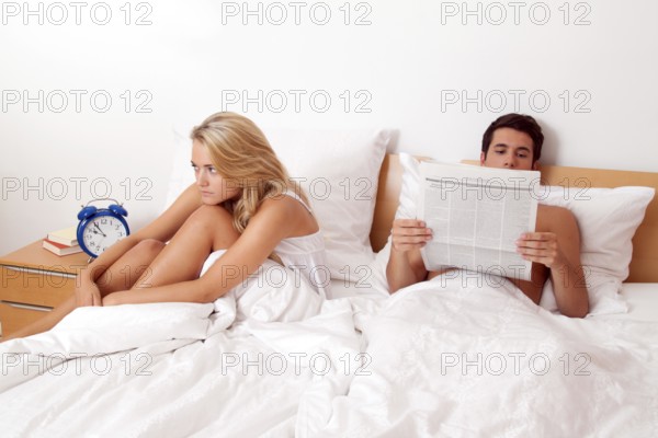 A young couple in bed having problems and crisis. Divorce and separation, A young couple in bed