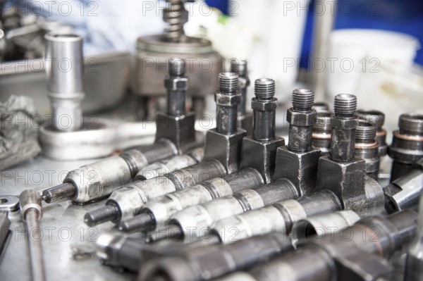 The old diesel injectors lie on the table in the fuel shop. The concept of repair of fuel diesel