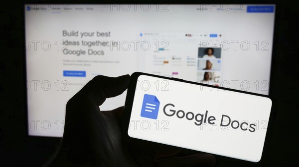 Stuttgart, Germany, 09-23-2023: Person holding mobile phone with logo of online word processing