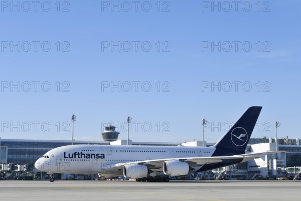 Lufthansa Airbus A380-800 with control tower, taxiing in front of Terminal 2 to runway South