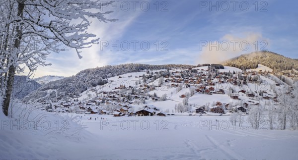Winter panorama of snow covered La Clusaz village nestled in a hilly landscape in Annecy, France.
