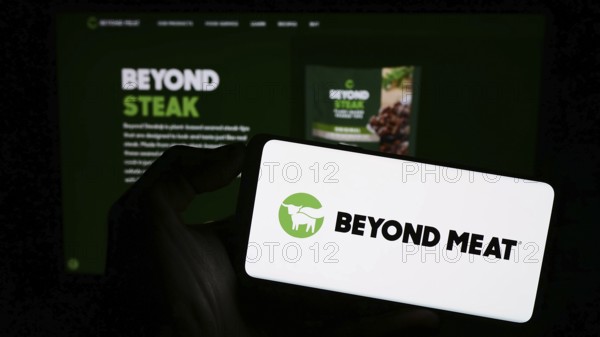 Stuttgart, Germany, 09-11-2023: Person holding mobile phone with logo of American meat substitute