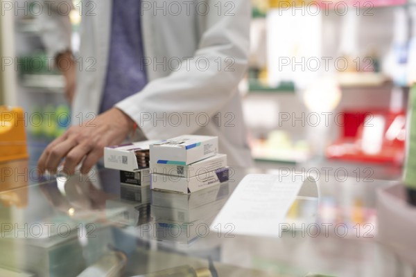 Medications stacked on a pharmacy counter, ready to be sold. Represents a typical scene in the