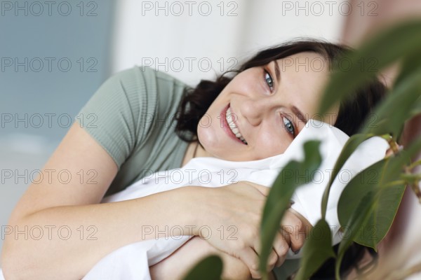 Happy cheerful young woman with big blue eyes resting relaxing at home on weekend, enjoying leisure