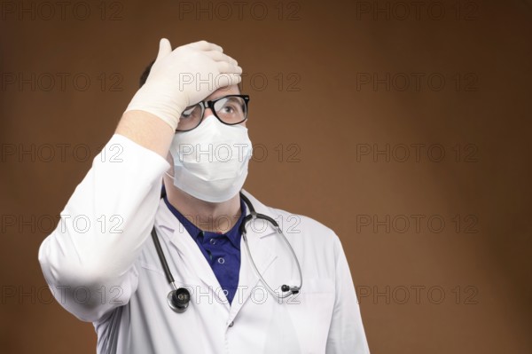 Male Caucasian doctor in white medical uniform shows face palm gesture. Chagrin and disappointment.