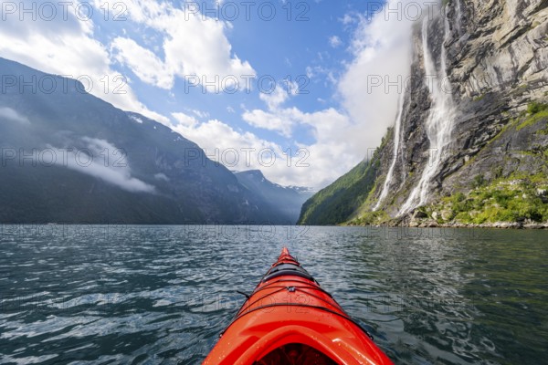 Kayak trip on the Geirangerfjord at the waterfall The Seven Sisters, tip of a red kayak in the