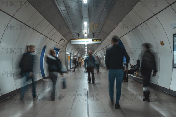 Tourists and commuters navigating an underground corridor in london, united kingdom, surrounded by