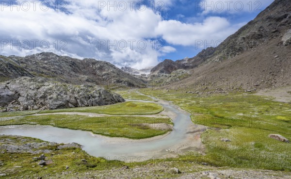 Mountain stream meanders through high mountain landscape on the Upper Senner Egete between meadows