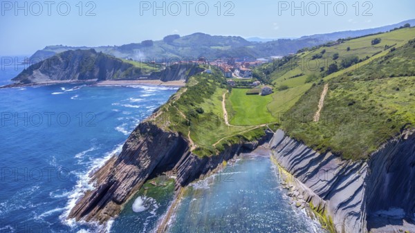 Aerial perspective captures the stunning beauty of zumaia's flysch cliffs meeting the vibrant blue