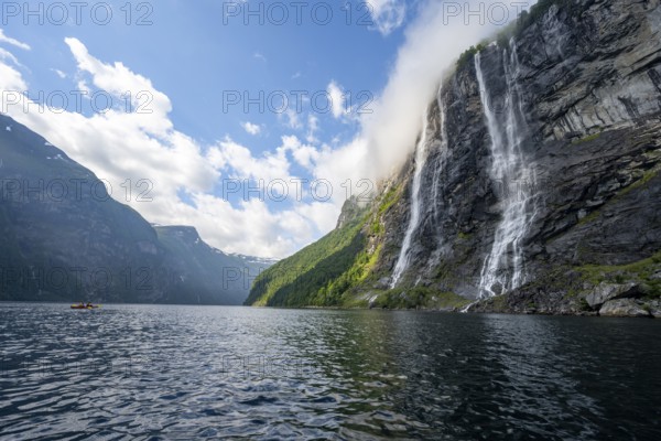 Geirangerfjord at the waterfall The Seven Sisters, tip of a red kayak in the fjord, atmospheric