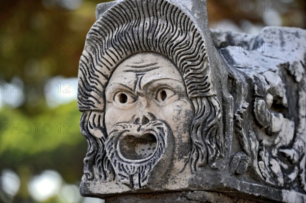 Ancient stone sculpture, stone carving of a mask, Roman theatre, ancient port city of Rome,