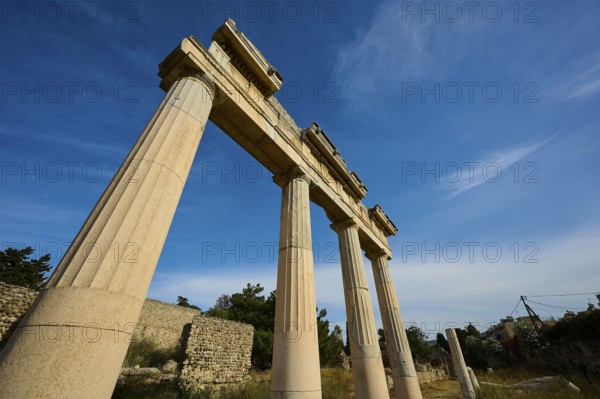 Ancient temple columns under a clear blue sky in a historical landscape, Archaeological site, Xysto