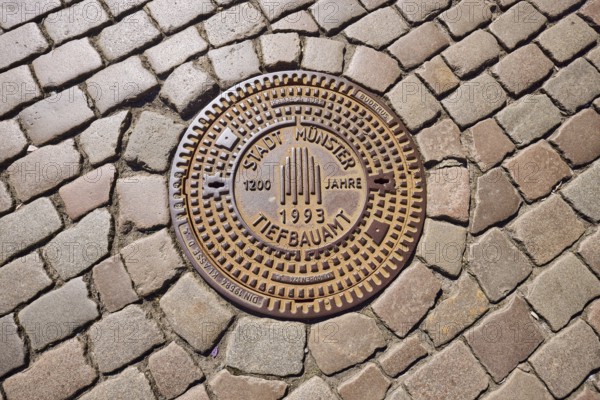 Manhole cover, city of Münster civil engineering, 1200 years 1993, cobblestones, Münster,