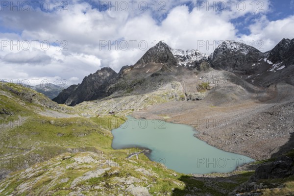 View of the turquoise-blue mountain lake Großer Gradensee, with the peaks of Petzeck and