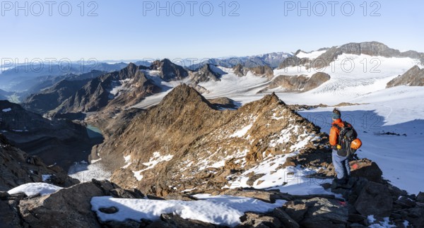 Mountaineer on a rocky ridge on the Wilder Freiger summit, behind him Signal summit and Becher