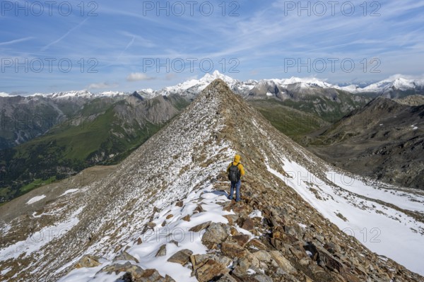 Mountaineer climbing to the summit of Böses Weibl, view of mountain landscape with snow-covered