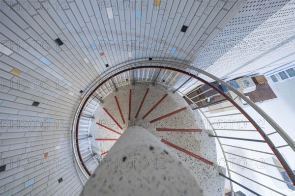 A modern spiral staircase with colourful tiles and bright lighting in a round shape, historical art