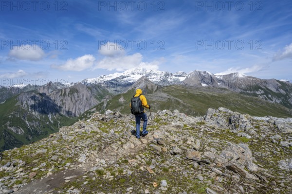 Mountaineers on a hiking trail, view of picturesque mountain landscape with snow-covered summit of