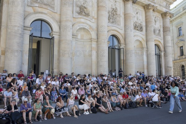 Visitors sit in the shade in front of St Hedwig's Cathedral without being able to see anything at