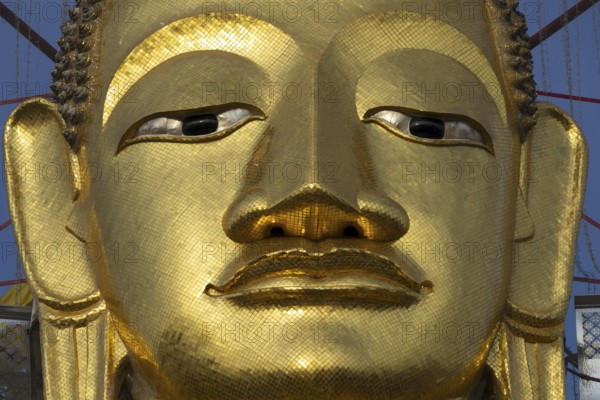 Face of a 32 metre high standing Buddha decorated with glass mosaics and 24-carat gold, Luang Pho