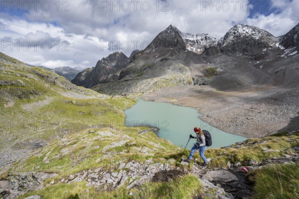 Mountaineer on hiking trail in mountain landscape, view of turquoise-blue mountain lake Großer