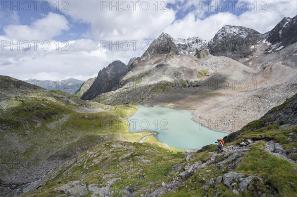 Mountaineer on hiking trail, view of turquoise-blue mountain lake Großer Gradensee, behind summit