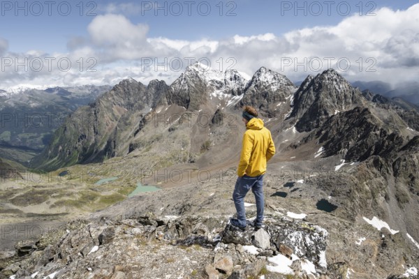 Mountaineer in rocky mountain landscape, at the summit of Keeskopf, behind summit of Petzeck, Hoher